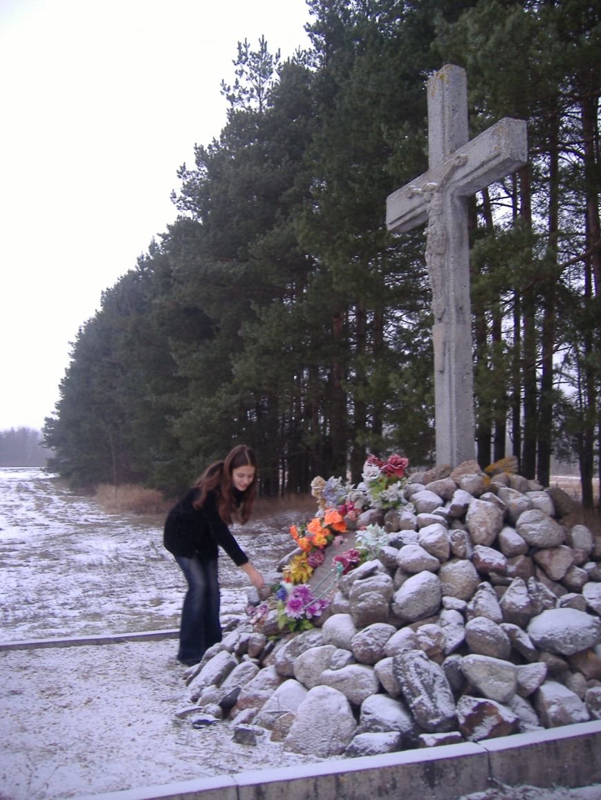 Крест на месте расстрела. Цветы – к подножию памятника